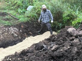 Pose de sable  pour maintenir le drain en place par l'équipe de l'association des marais septentrionaux du Laonnois 